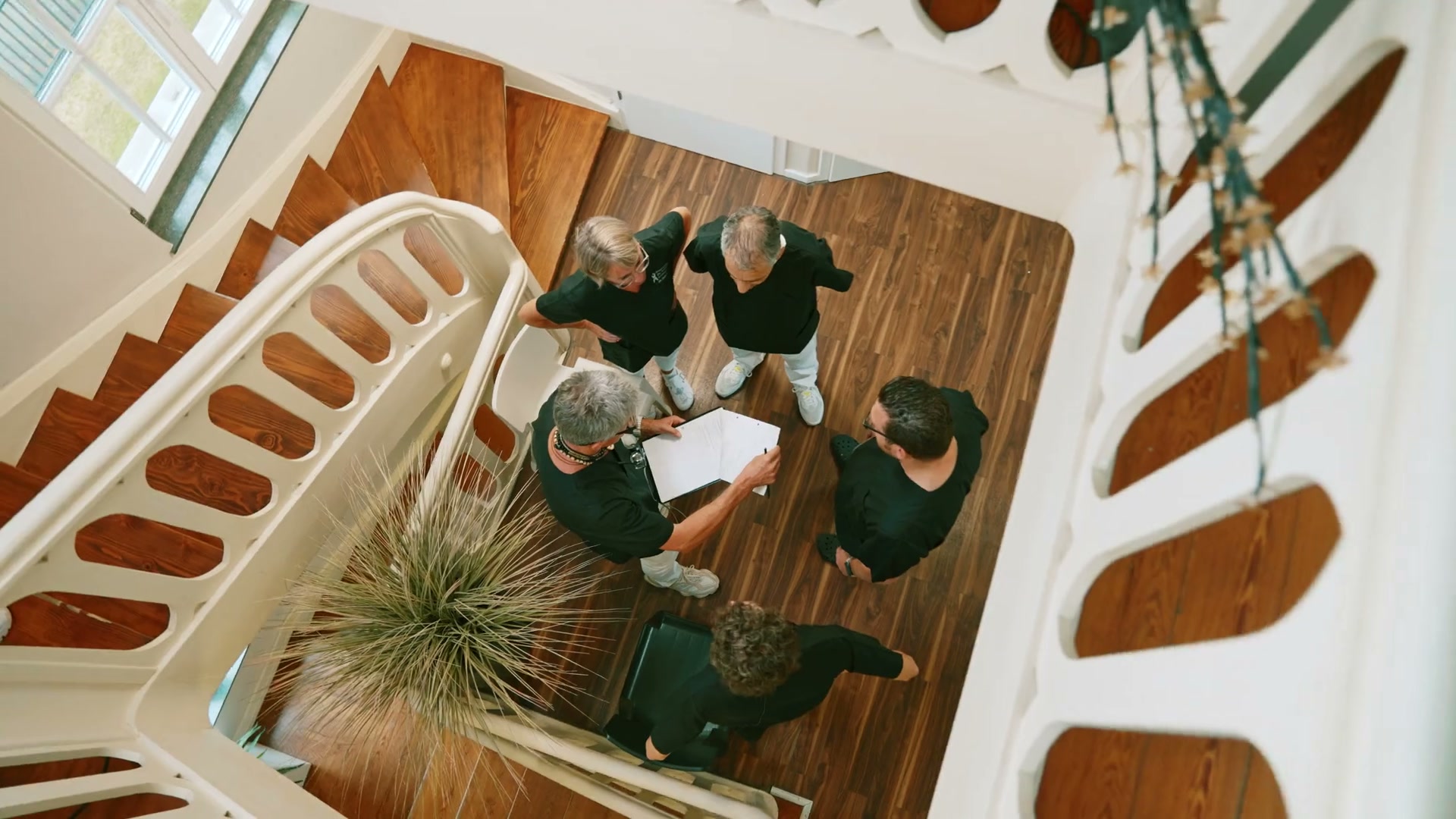 Das Team der Praxisklinik von oben – Blick durchs Treppenhaus der Villa