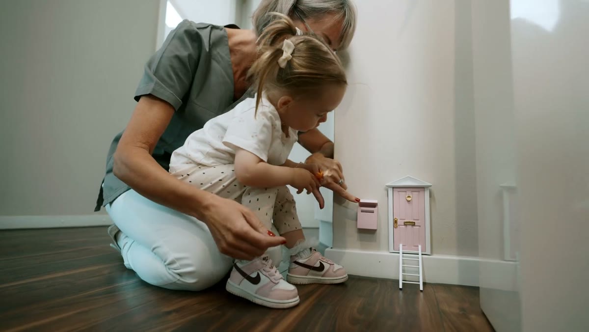Kleine Patientin entdeckt das Zahnfee-Türchen in der Praxis